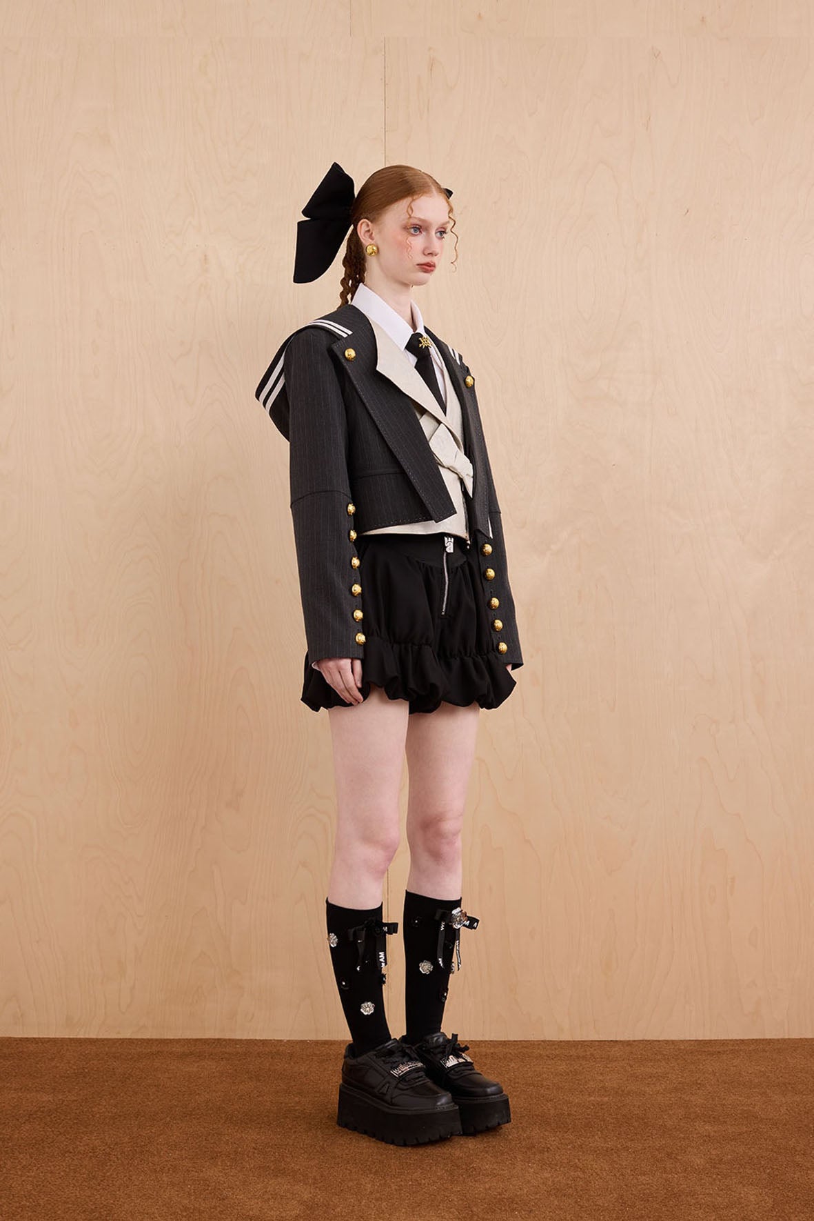 Model wearing Samurai hooded cropped blazer with slanted collar and bow detail