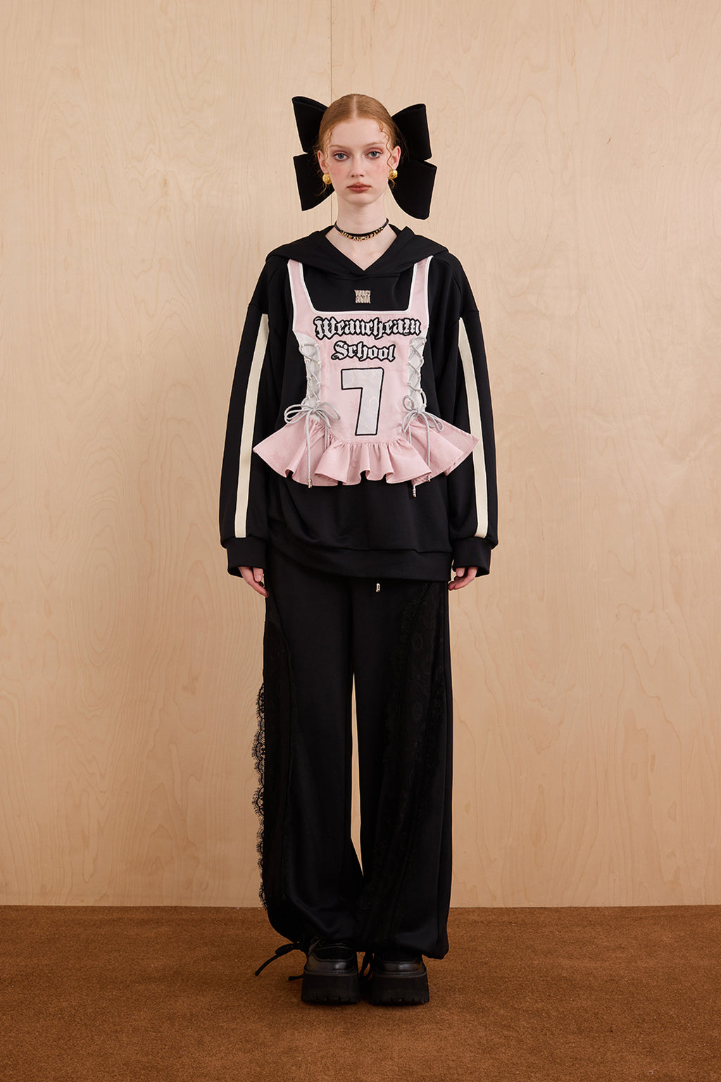 Model wearing oversized cat ear hoodie sweatshirt with bow tie details