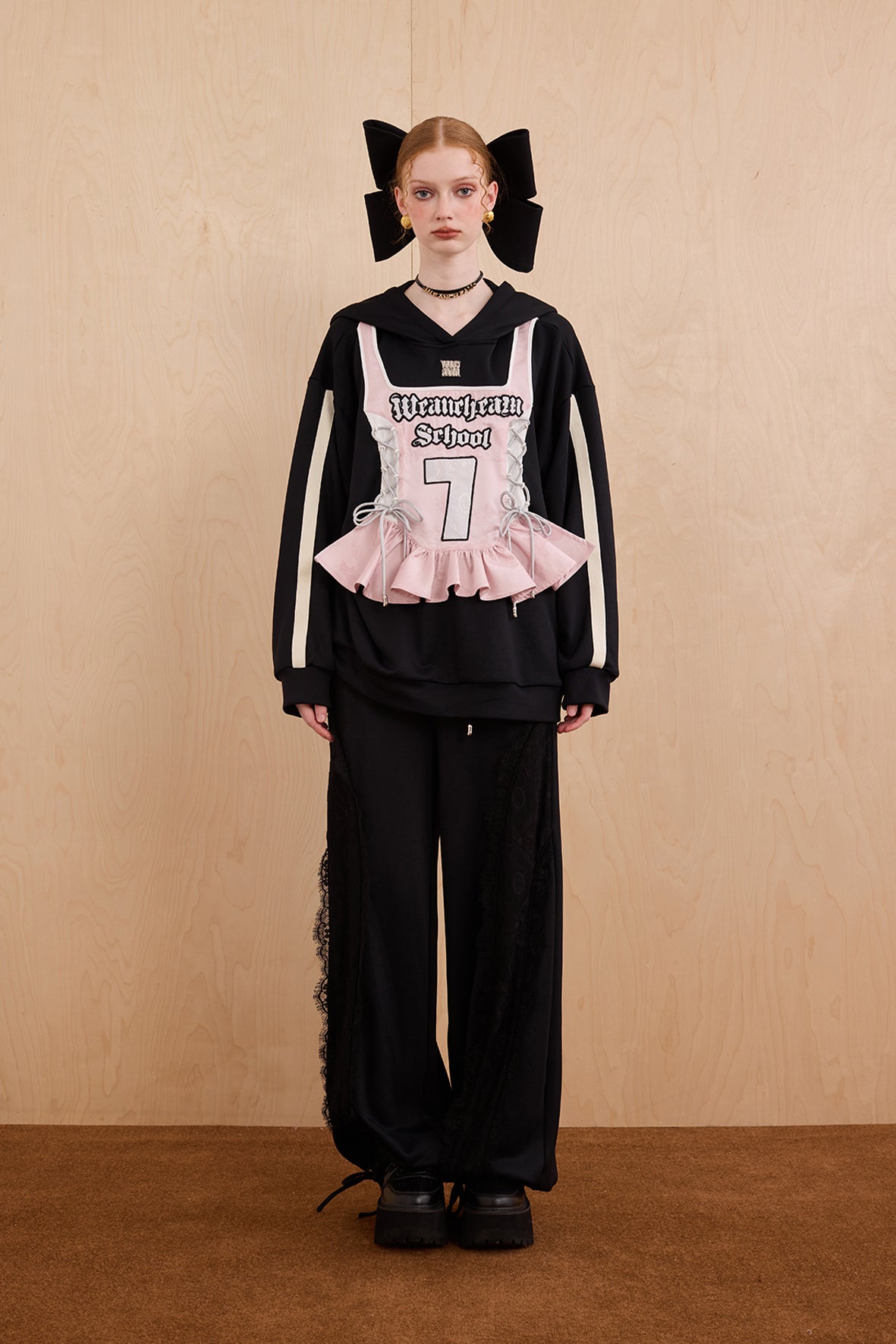 Model wearing oversized cat ear hoodie sweatshirt with bow tie details