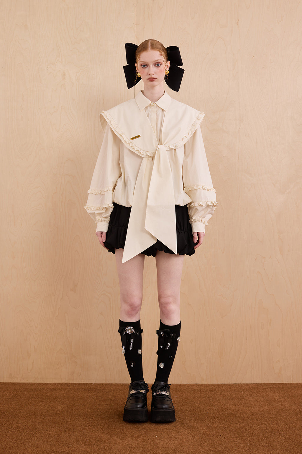 Model wearing college-style shirt with detachable navy collar and bubble hem