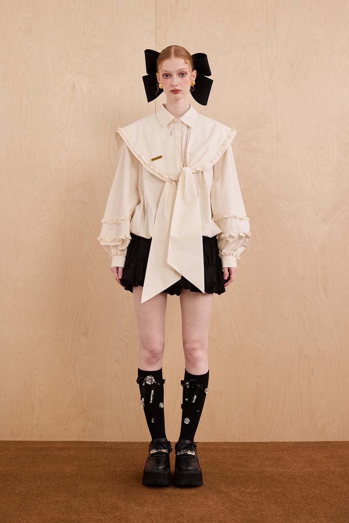 Model wearing college-style shirt with detachable navy collar and bubble hem