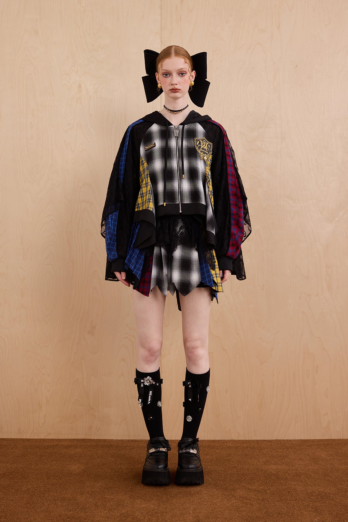 Model wearing loose-fit patchwork caped jacket with elegant lace accents