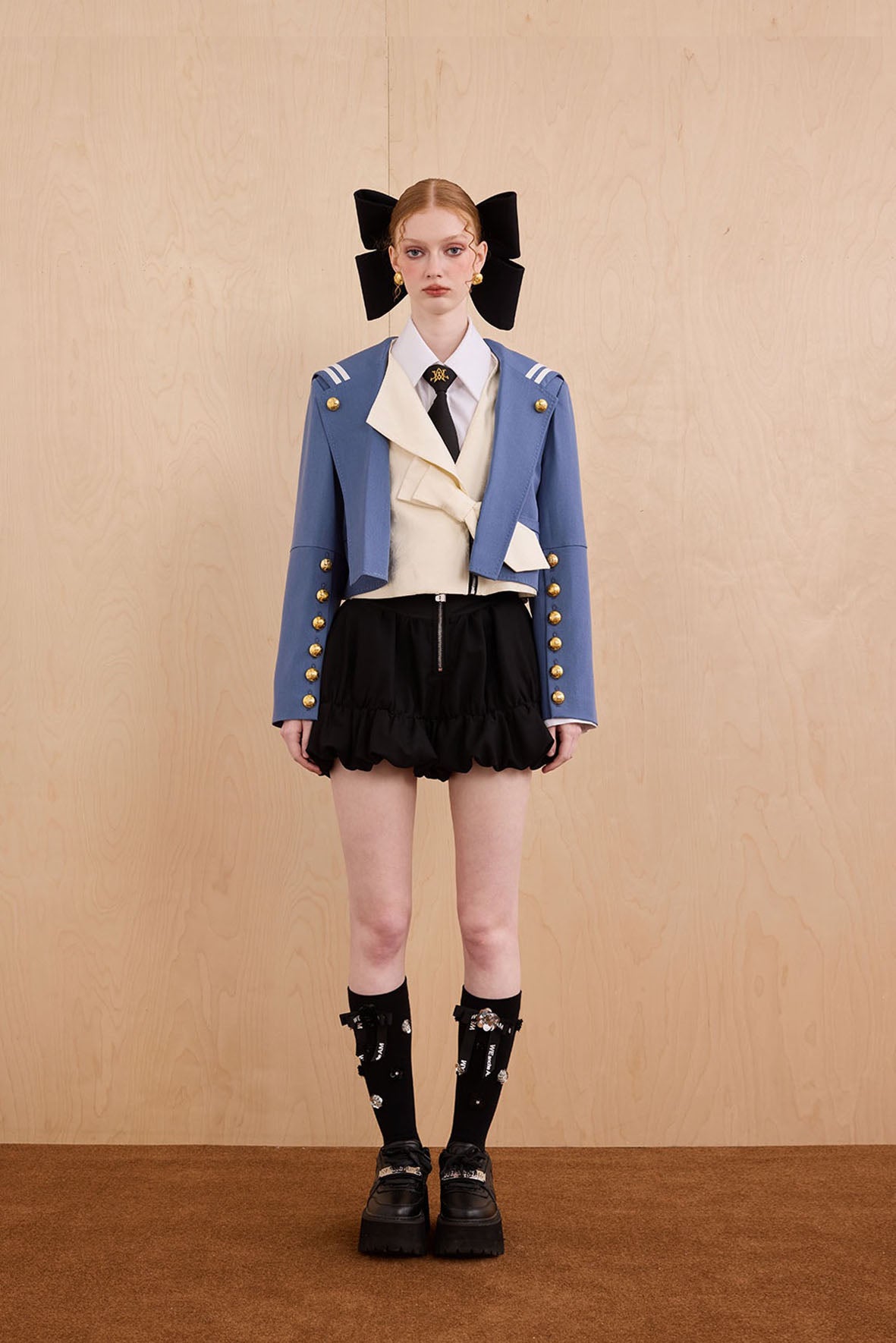 Model wearing Samurai hooded cropped blazer with slanted collar and bow detail