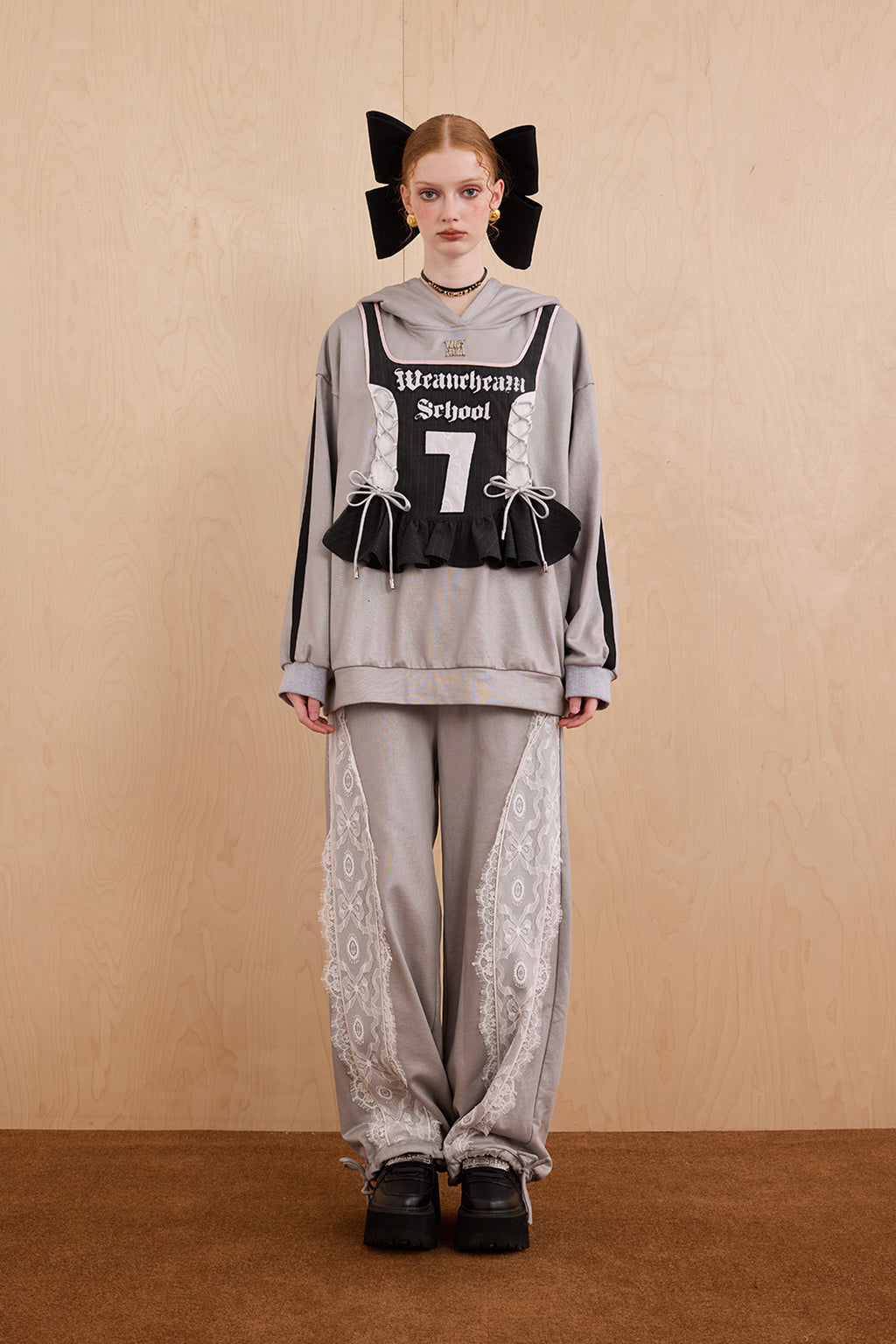 Model wearing oversized cat ear hoodie sweatshirt with bow tie details