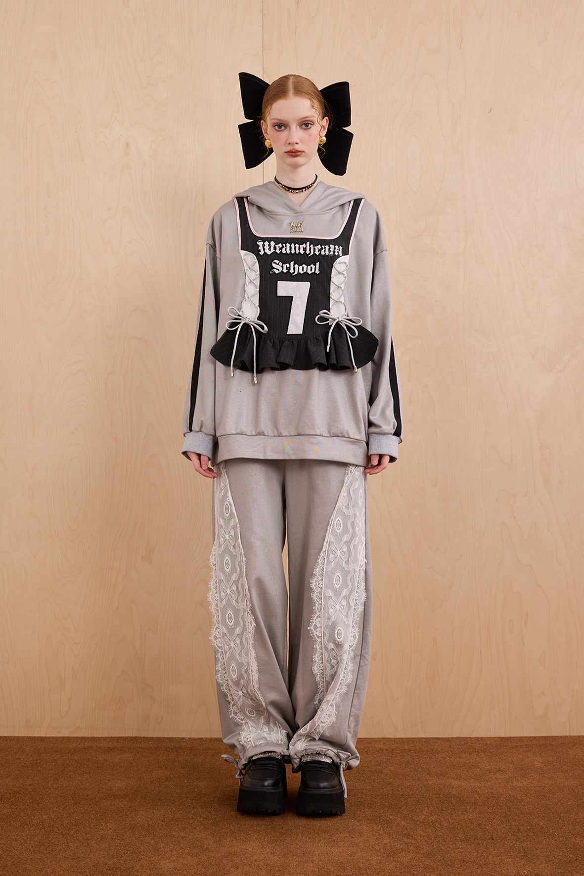 Model wearing oversized cat ear hoodie sweatshirt with bow tie details