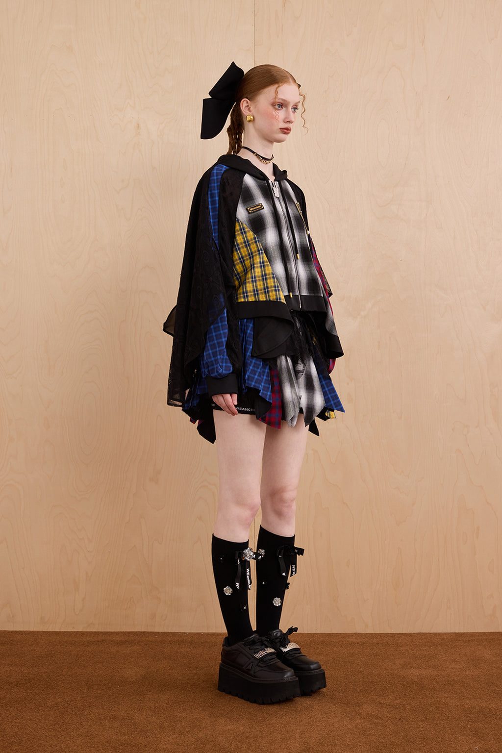 Model wearing loose-fit patchwork caped jacket with elegant lace accents