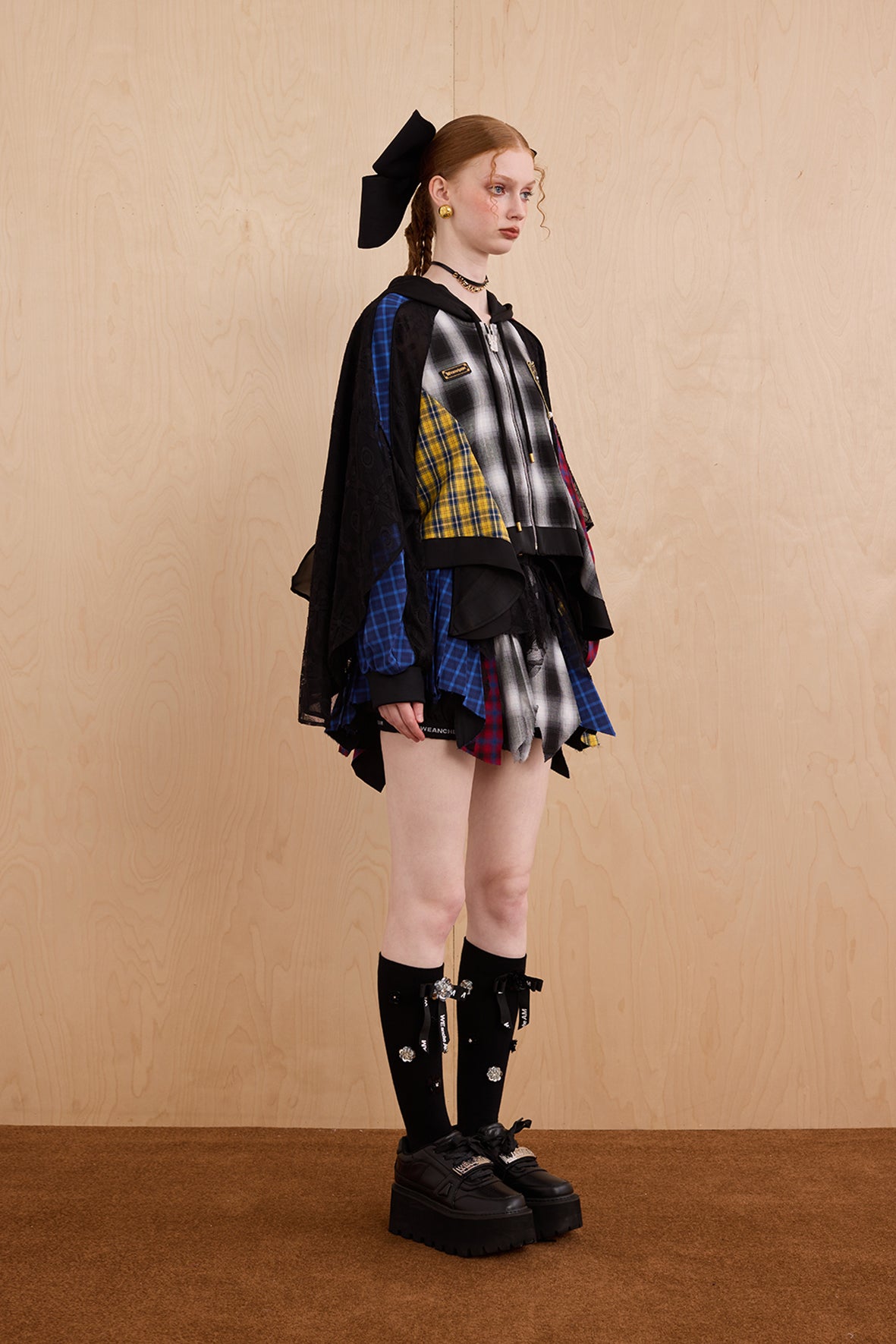 Model wearing loose-fit patchwork caped jacket with elegant lace accents