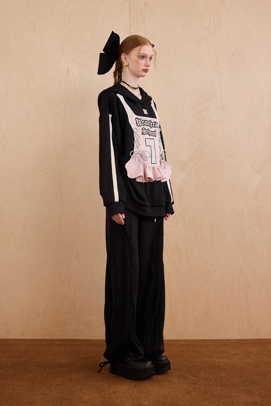 Model wearing oversized cat ear hoodie sweatshirt with bow tie details