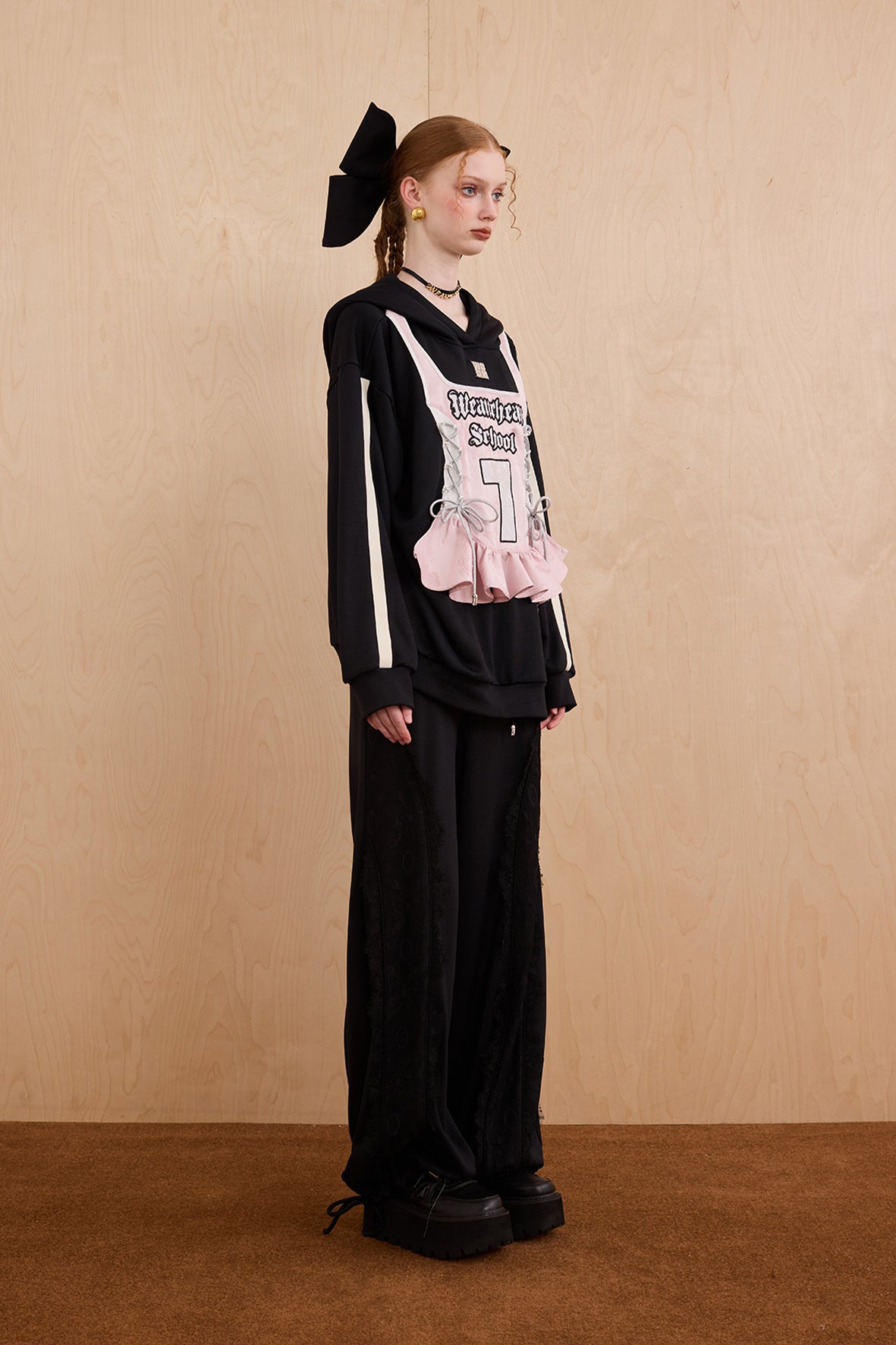 Model wearing oversized cat ear hoodie sweatshirt with bow tie details