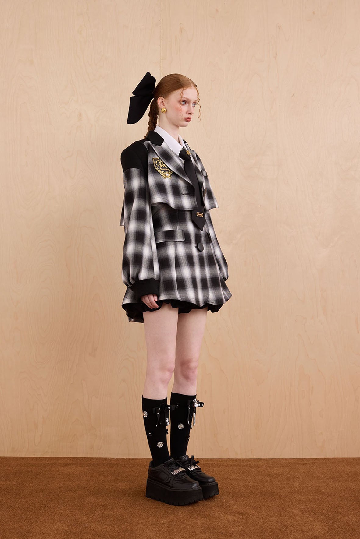 Model wearing two-piece fitted suit with windowpane check and shoulder patchwork