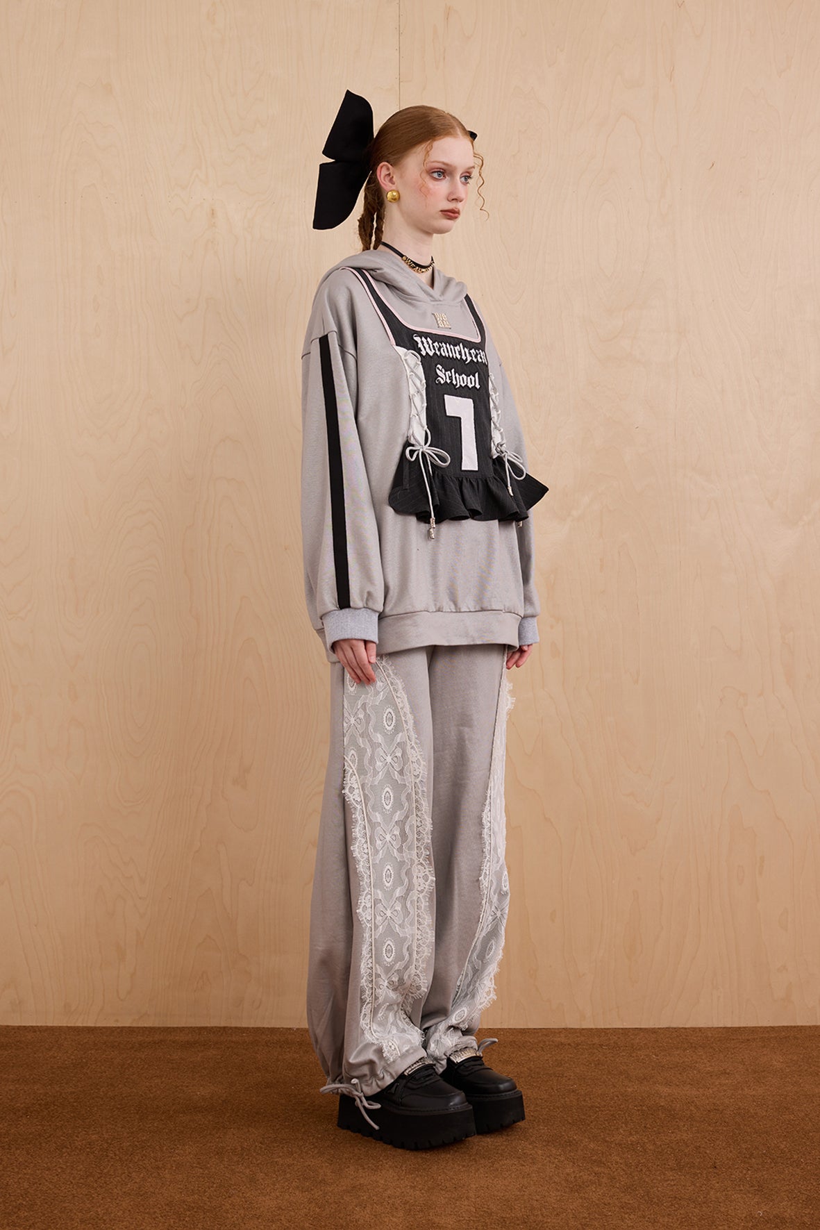 Model wearing oversized cat ear hoodie sweatshirt with bow tie details
