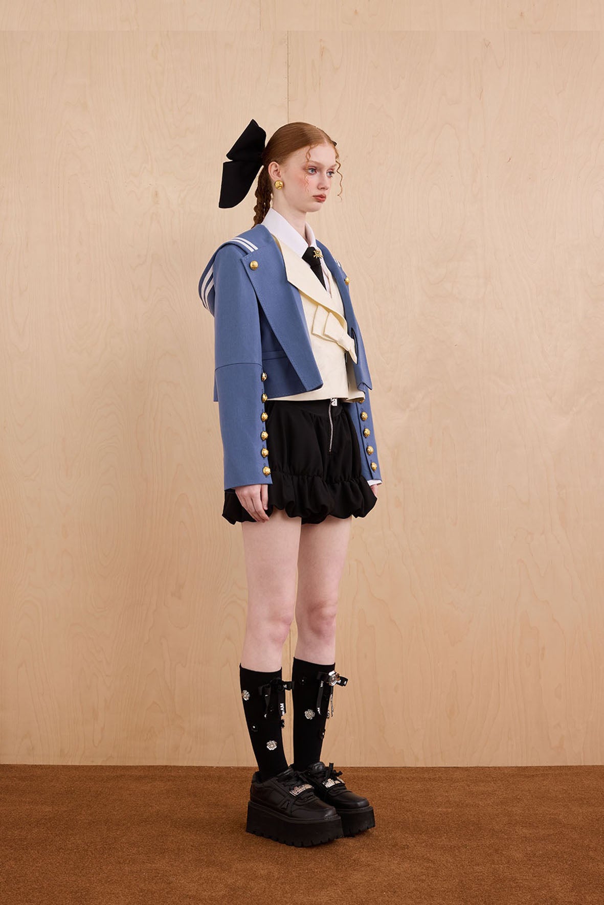 Model wearing Samurai hooded cropped blazer with slanted collar and bow detail
