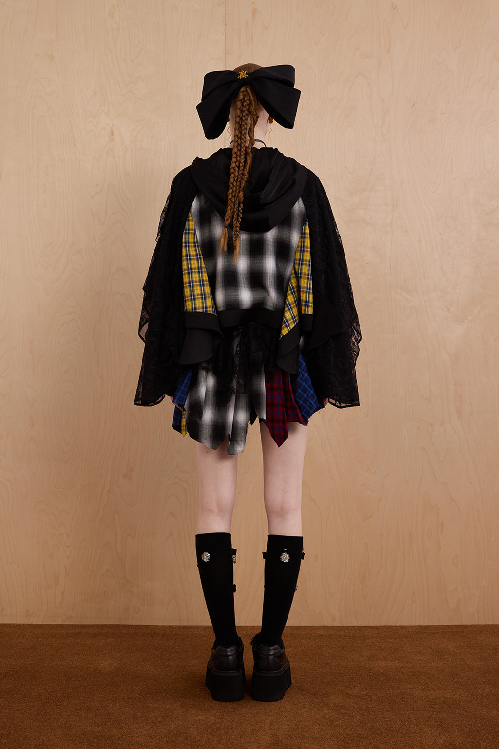 Model wearing loose-fit patchwork caped jacket with elegant lace accents