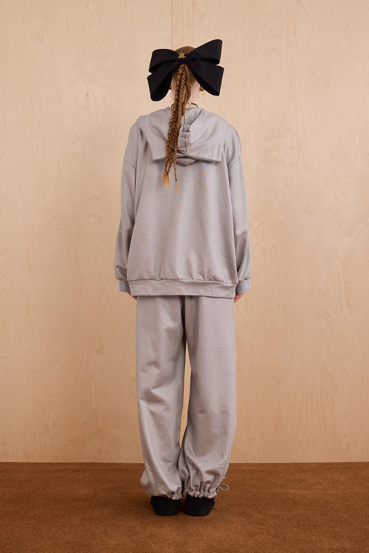 Model wearing oversized cat ear hoodie sweatshirt with bow tie details