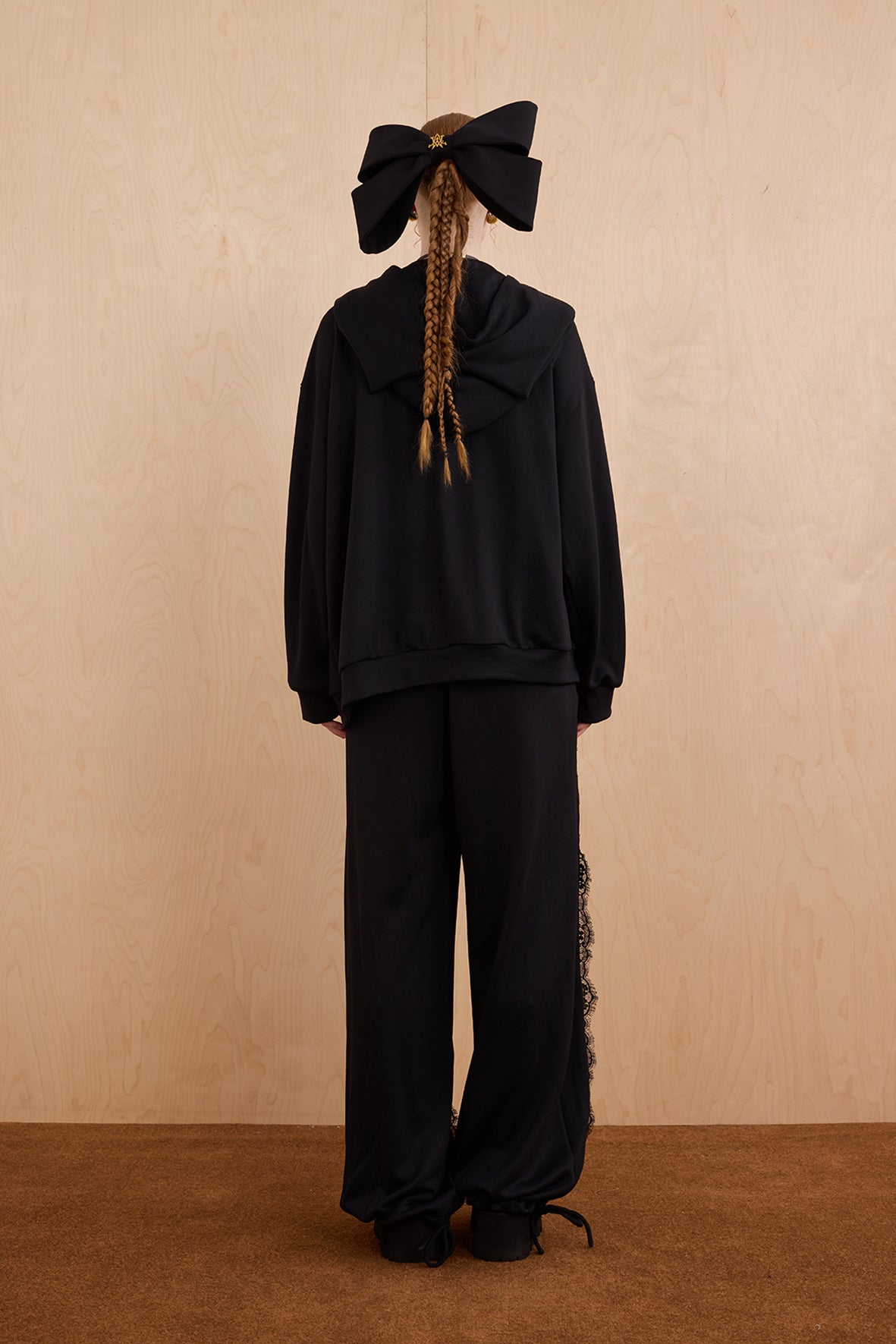 Model wearing oversized cat ear hoodie sweatshirt with bow tie details