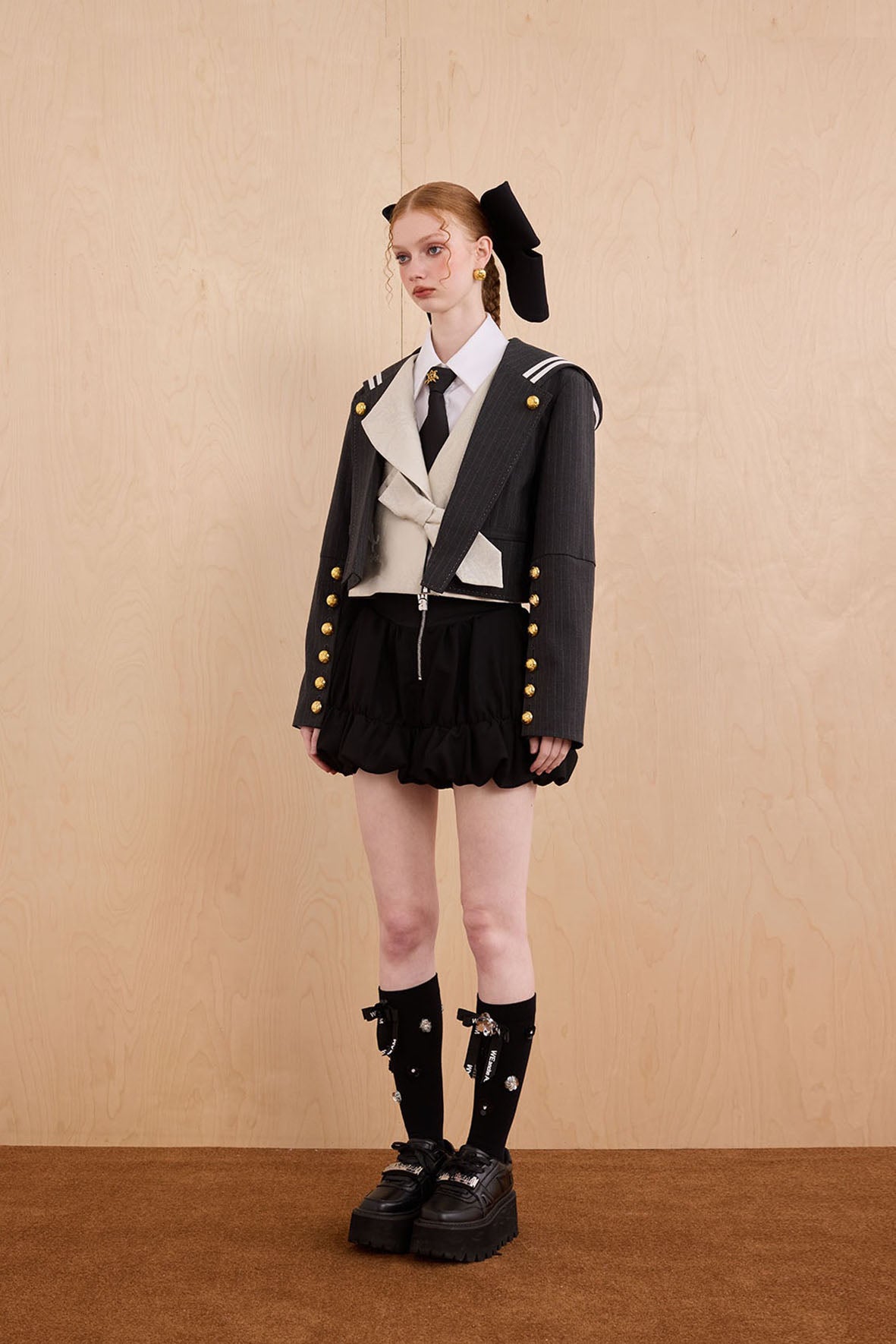 Model wearing Samurai hooded cropped blazer with slanted collar and bow detail