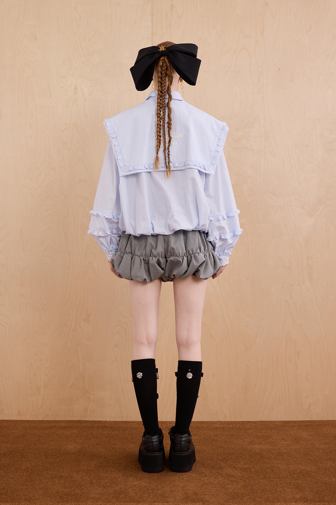 Model wearing college-style shirt with detachable navy collar and bubble hem