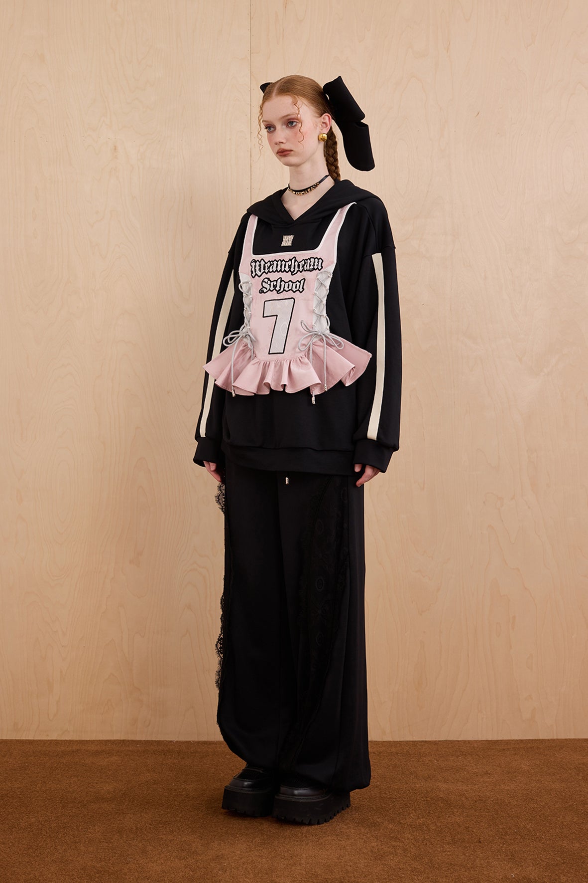 Model wearing oversized cat ear hoodie sweatshirt with bow tie details