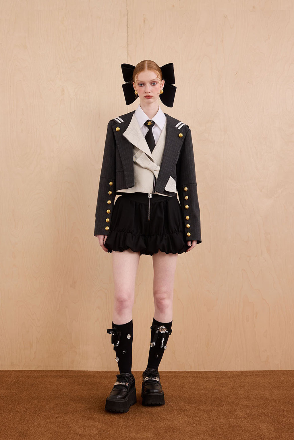 Model wearing Samurai hooded cropped blazer with slanted collar and bow detail