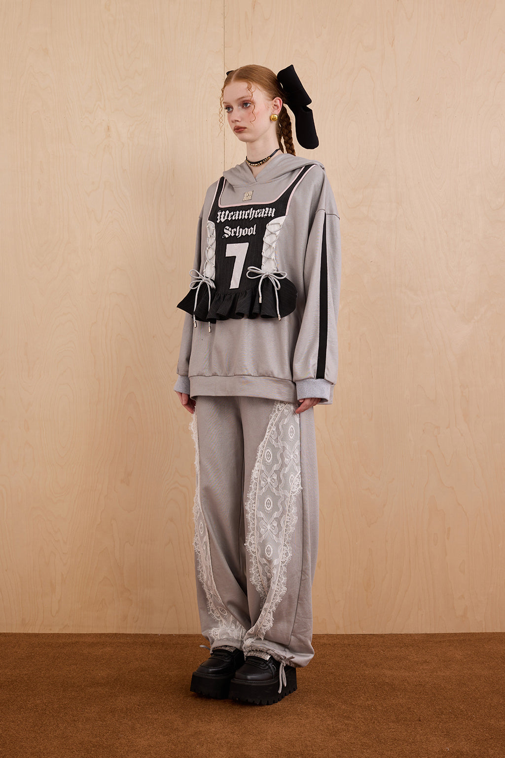 Model wearing oversized cat ear hoodie sweatshirt with bow tie details