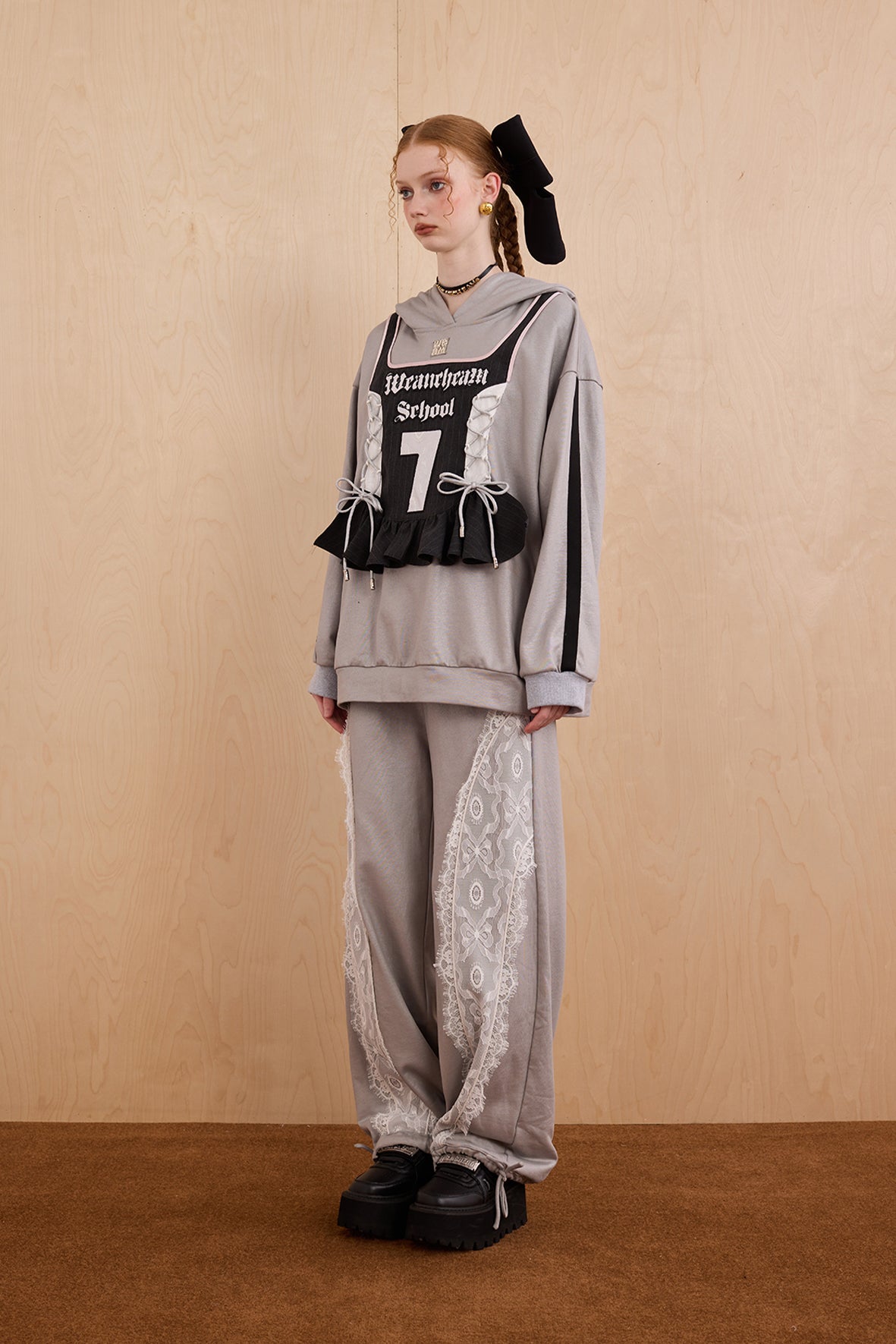Model wearing oversized cat ear hoodie sweatshirt with bow tie details