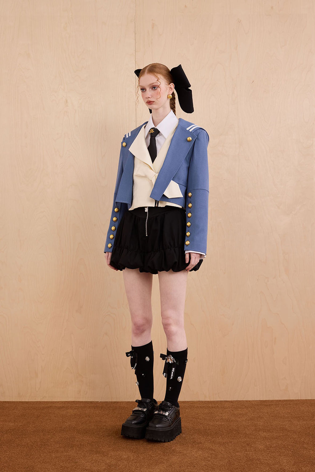 Model wearing Samurai hooded cropped blazer with slanted collar and bow detail