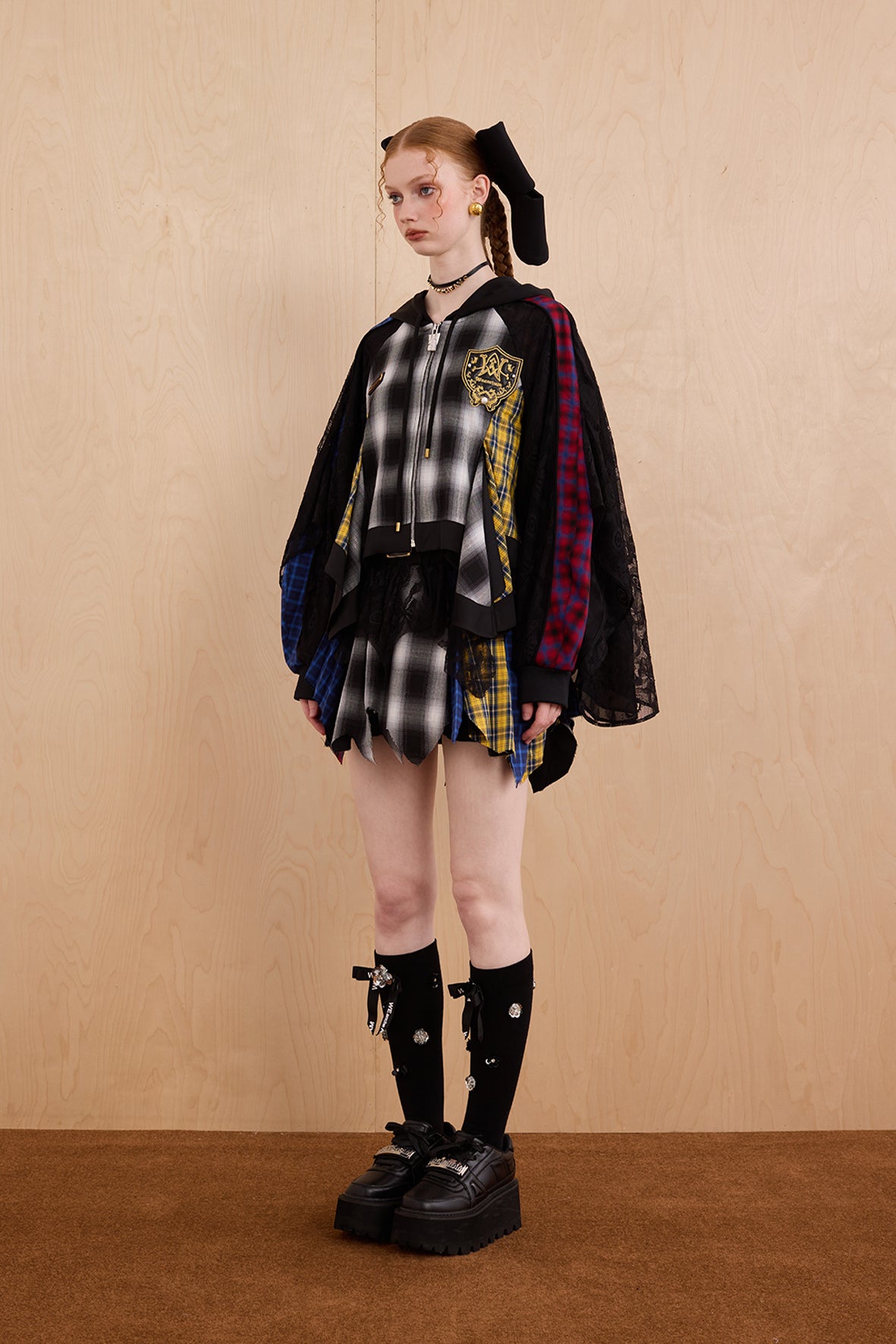 Model wearing loose-fit patchwork caped jacket with elegant lace accents