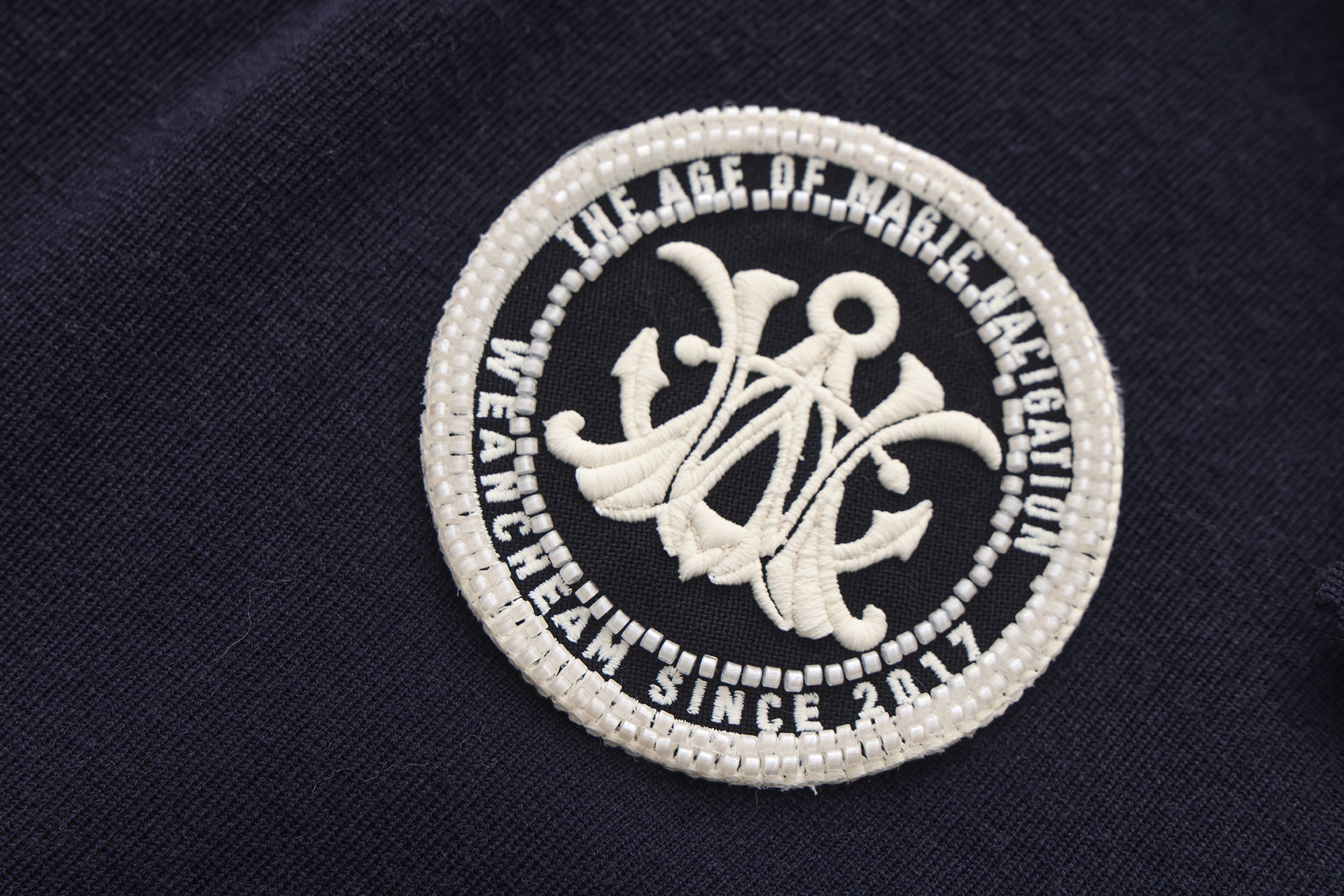 Close-up of navy collar and ribbon tie detail on retro knitted jacket