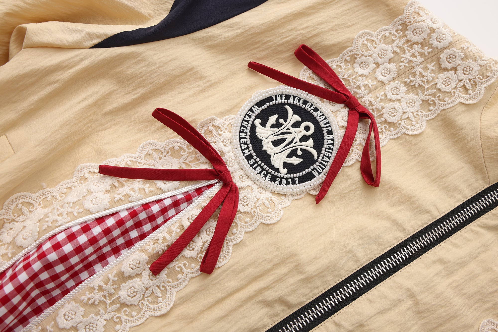 Close-up of lace bow trim and embroidered lace patchwork detail on jacket