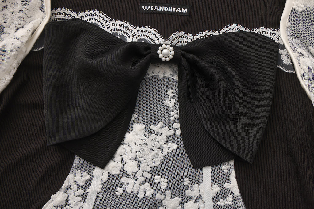 Close-up of lace fabric, detachable sleeve detail, and bow accent on vintage-style top