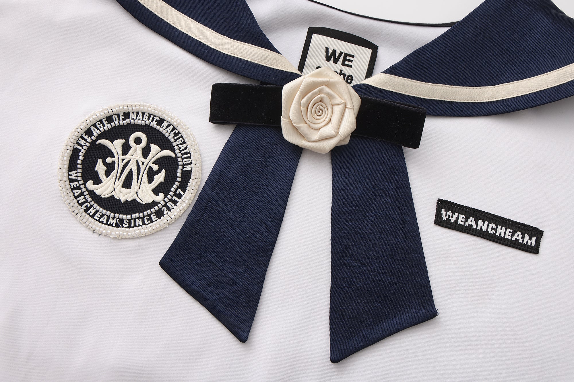 Close-up of satin navy collar and silk flower detail on cotton-modal T-shirt