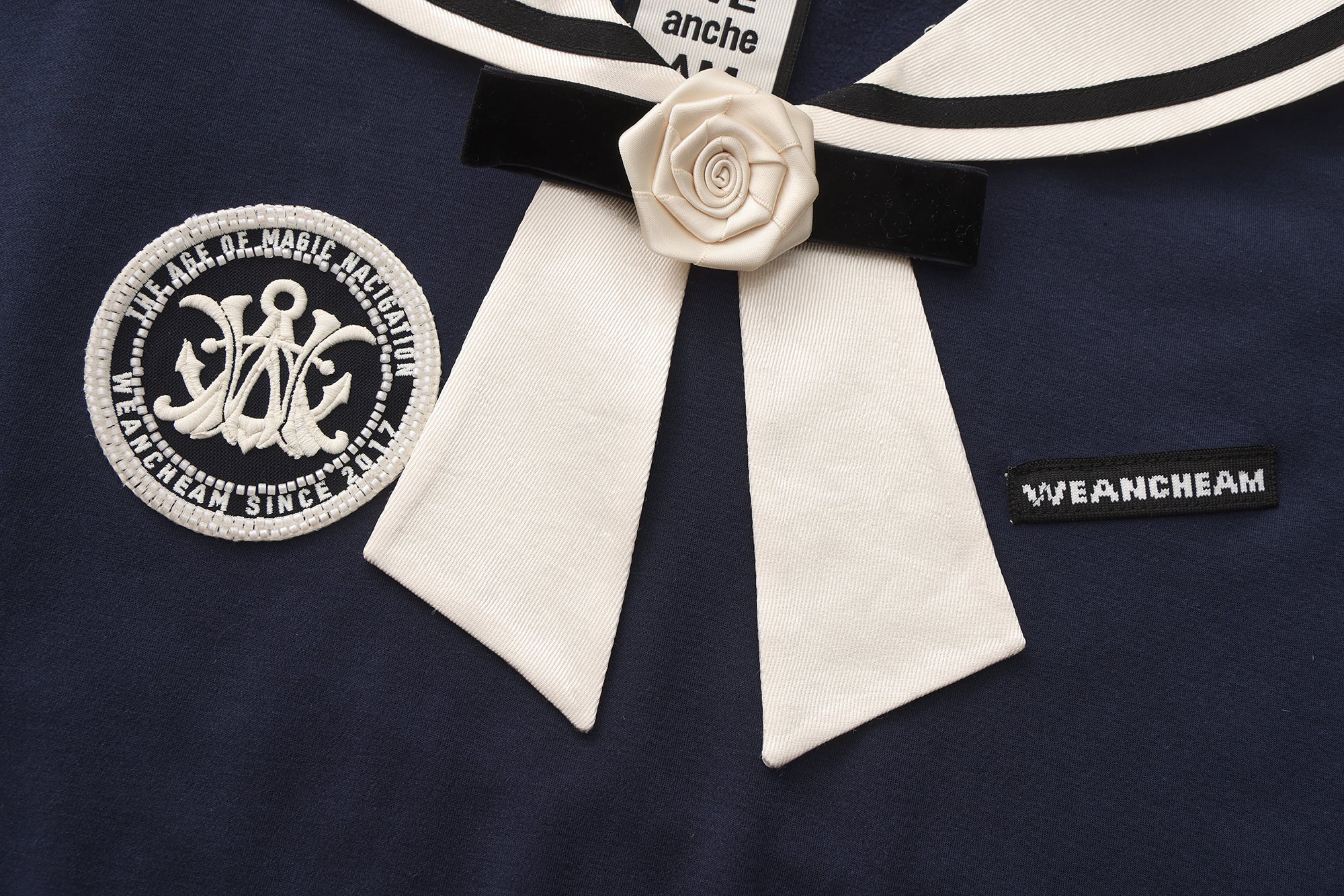 Close-up of satin navy collar and silk flower detail on cotton-modal T-shirt