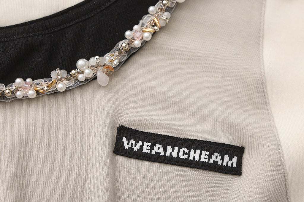 Close-up of beaded floral accent and layered faux two-piece detail on T-shirt