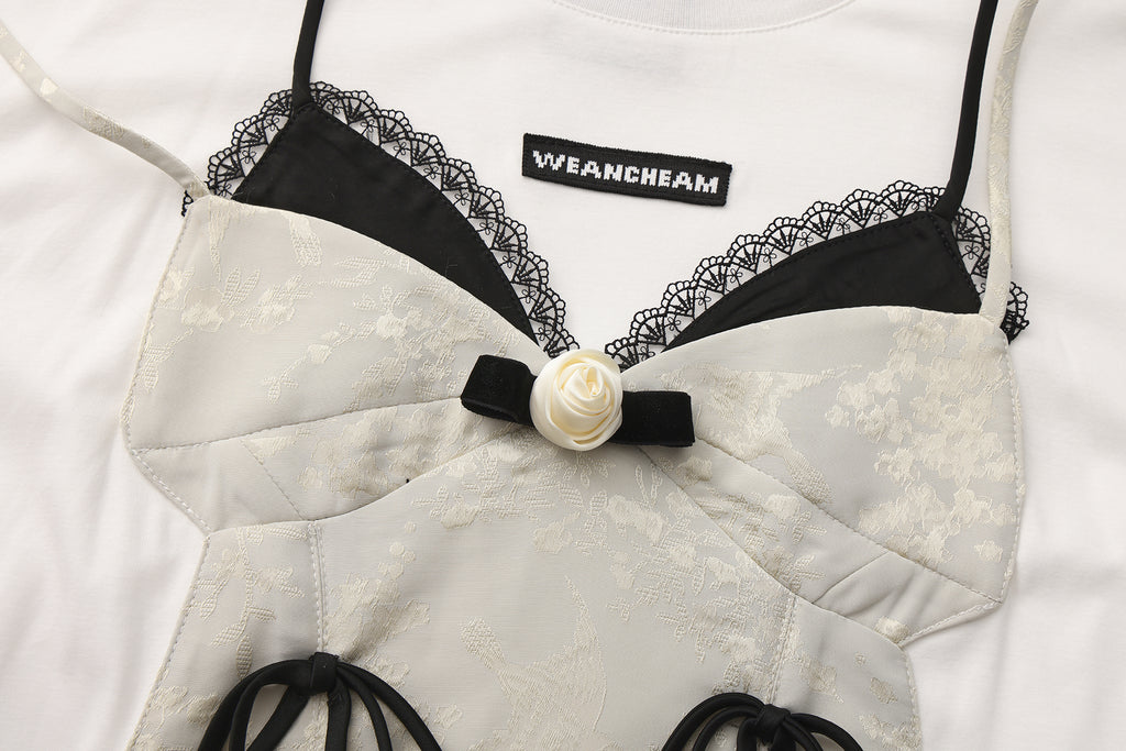 Close-up of satin halter overlay and lace-appliquéd hem on bow T-shirt