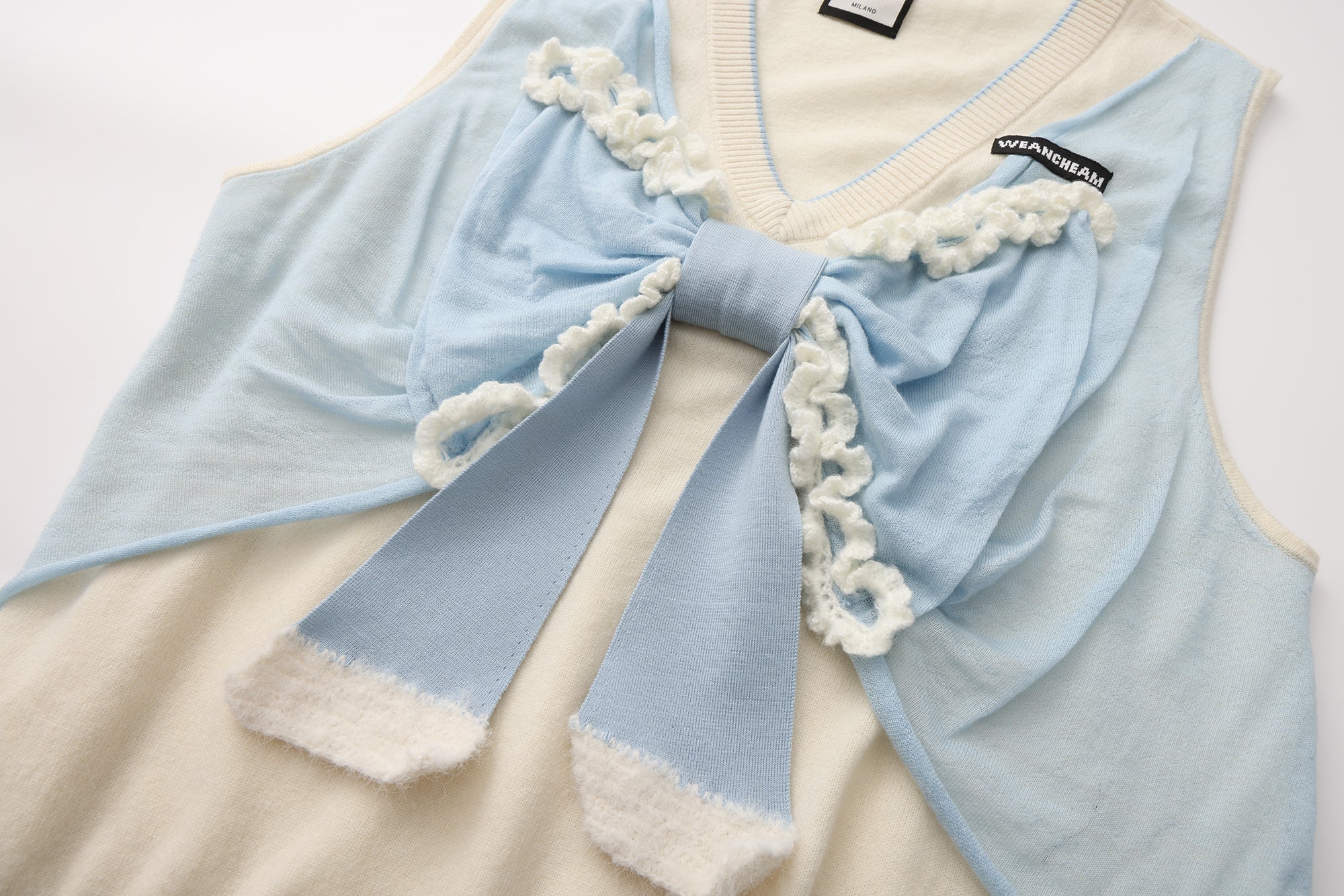 Close-up of crocheted edge and wool knit texture on bow tank top