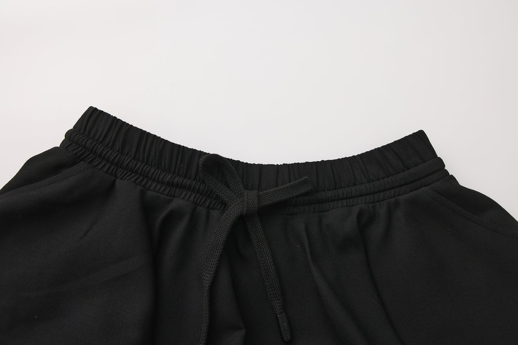 Close-up of elastic waistband and layered pleated wool-blend skirt detail
