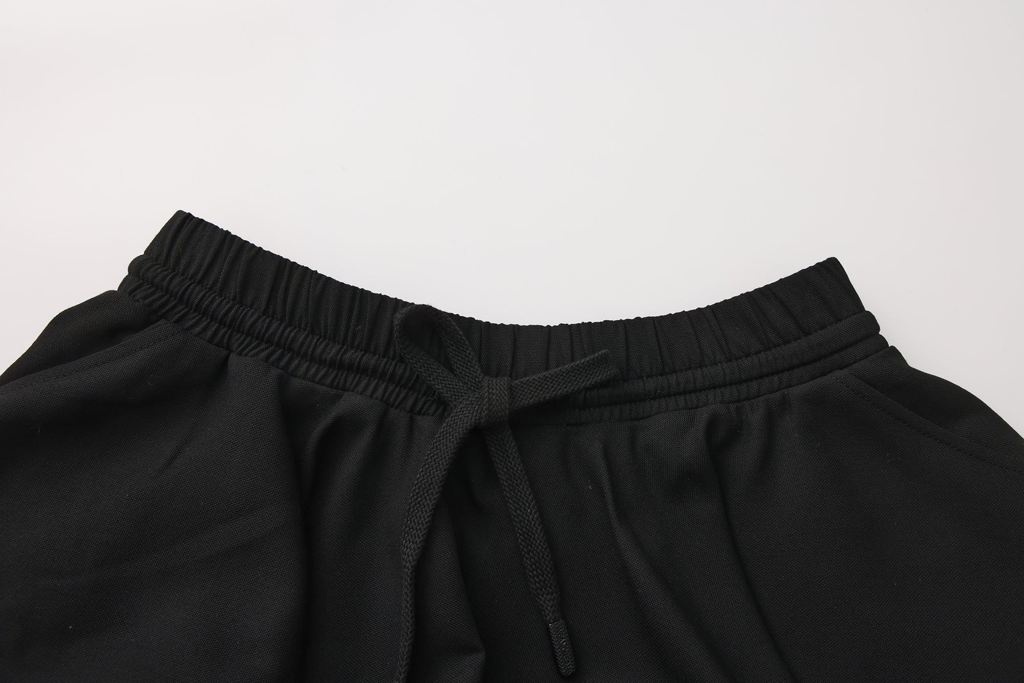 Close-up of elastic waistband and layered pleated wool-blend skirt detail