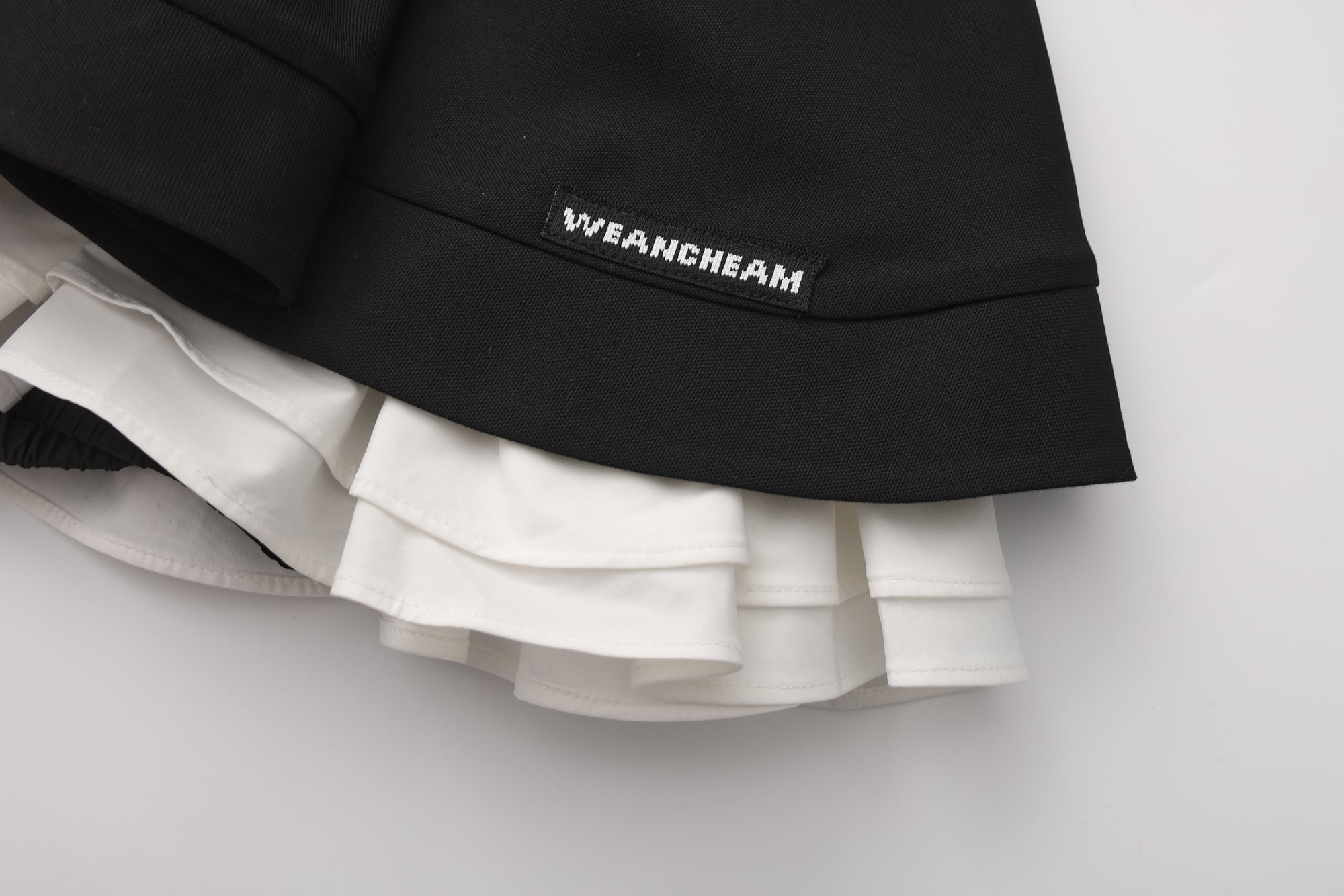 Close-up of elastic waistband and layered pleated wool-blend skirt detail