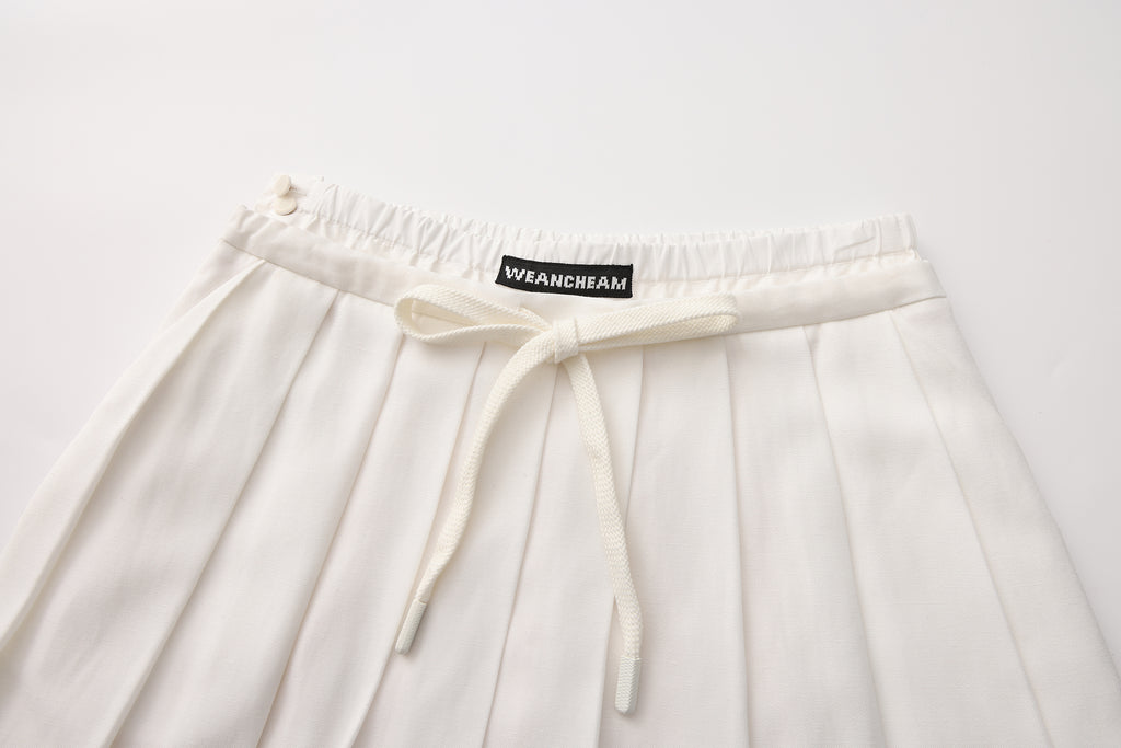 Close-up of lace-trim hem and double waistband detail on pleated skirt