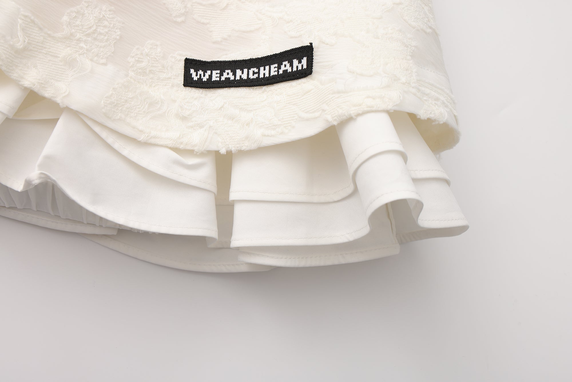 Close-up of elastic waistband and layered pleated wool-blend skirt detail