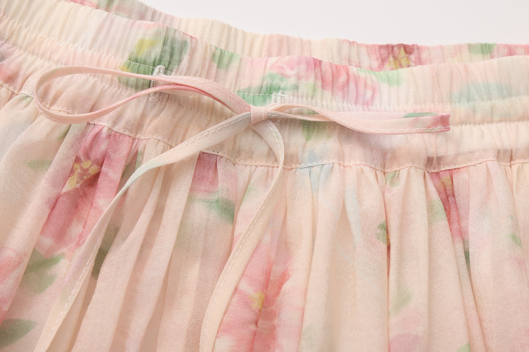 Close-up of lace hem, fishbone silhouette, and beaded waist detail on skirt