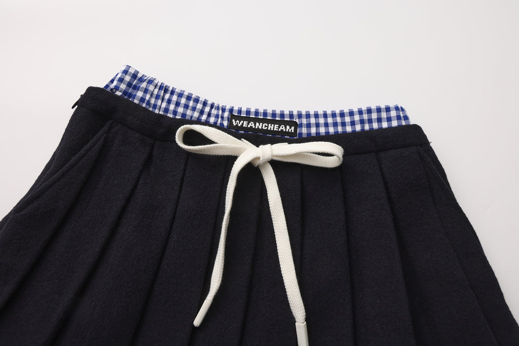 Close-up of lace-trim hem and double waistband detail on pleated skirt