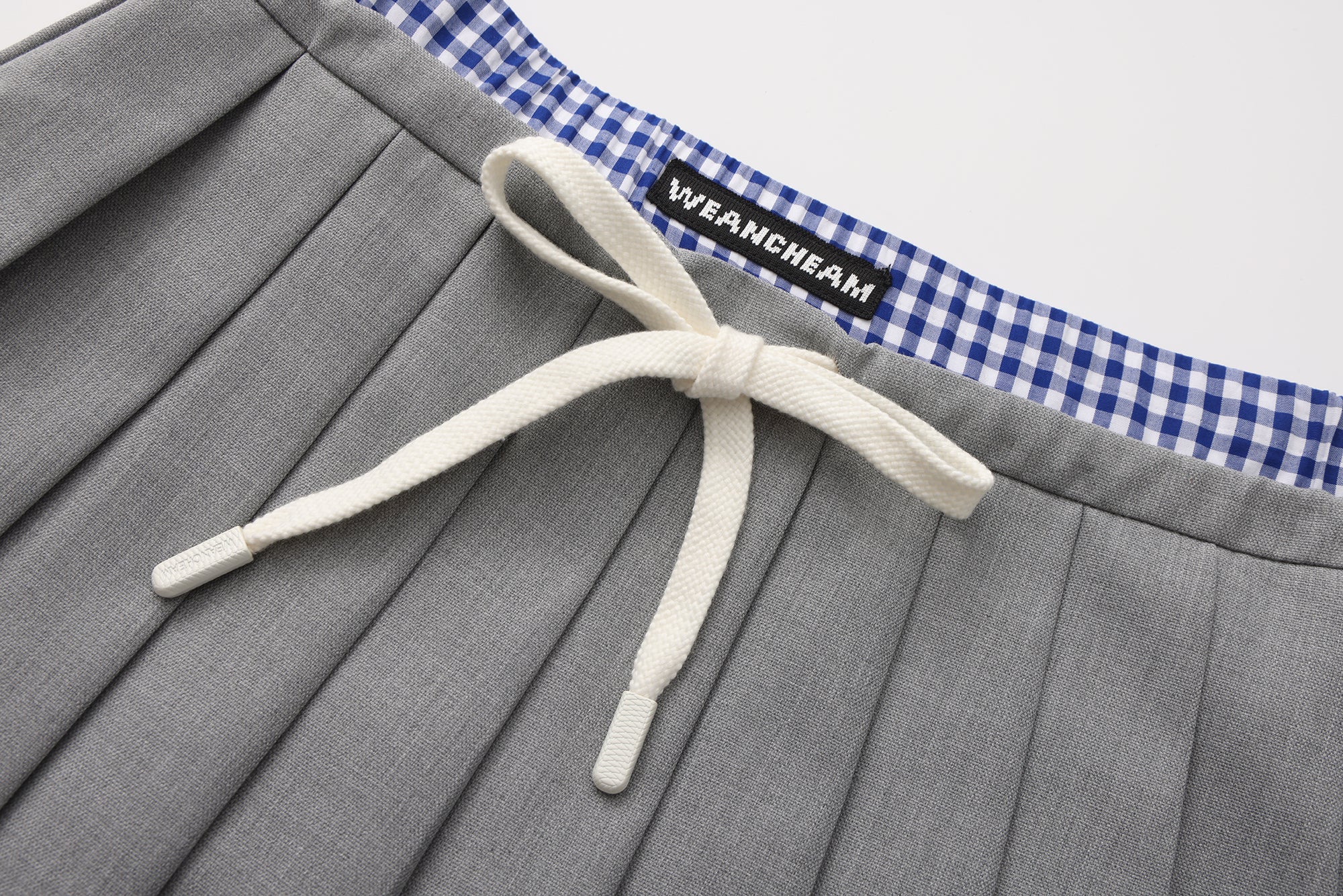 Close-up of pleated fabric and checkered contrast on wool-cashmere skirt