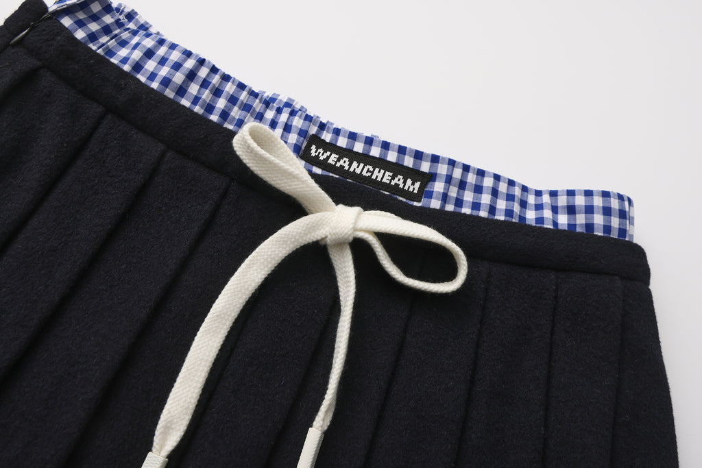 Close-up of pleated fabric and checkered contrast on wool-cashmere skirt