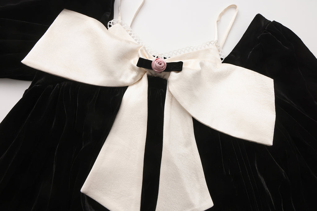 Close-up of sculptural bow and layered neckline on two-piece dress
