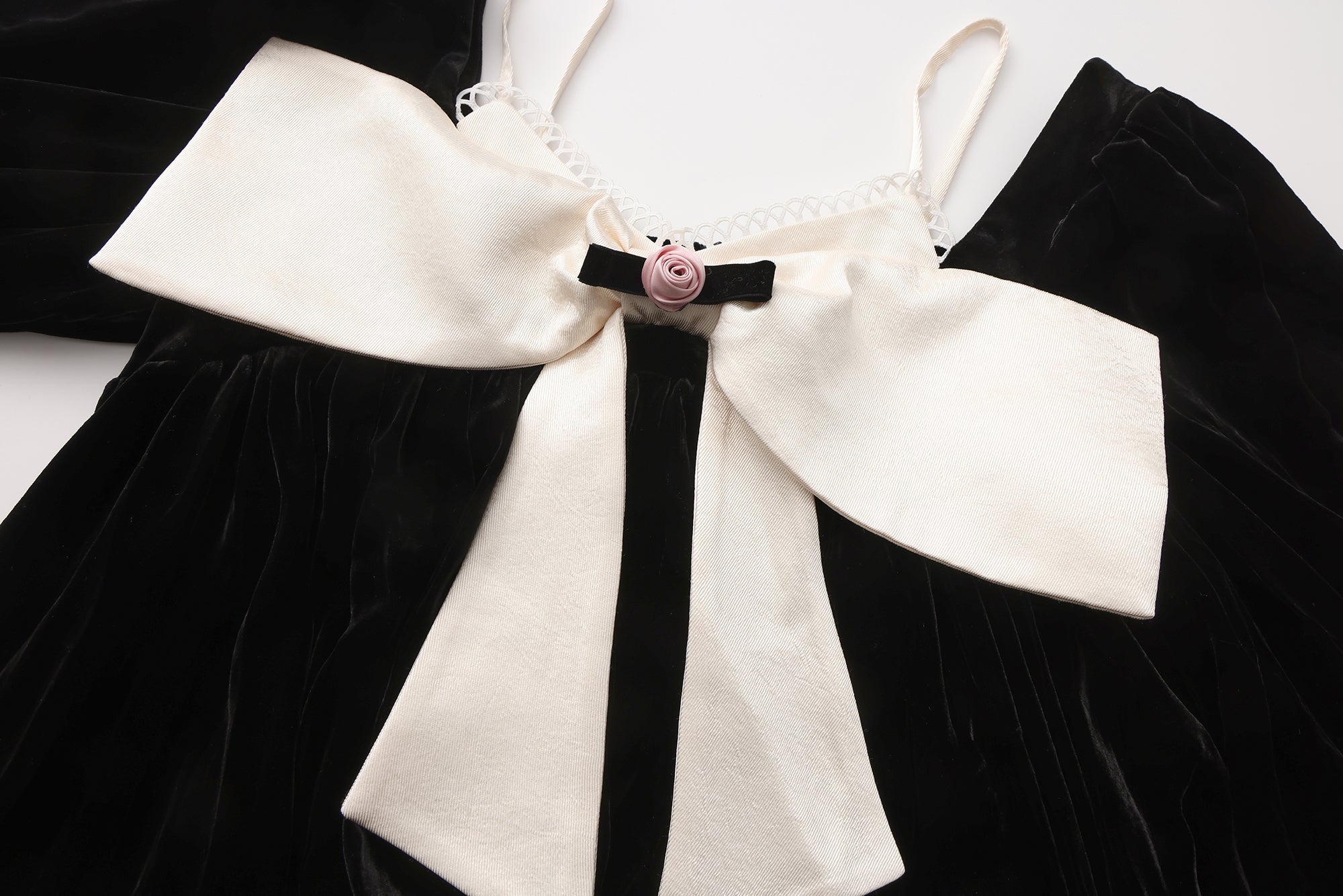 Close-up of sculptural bow and layered neckline on two-piece dress