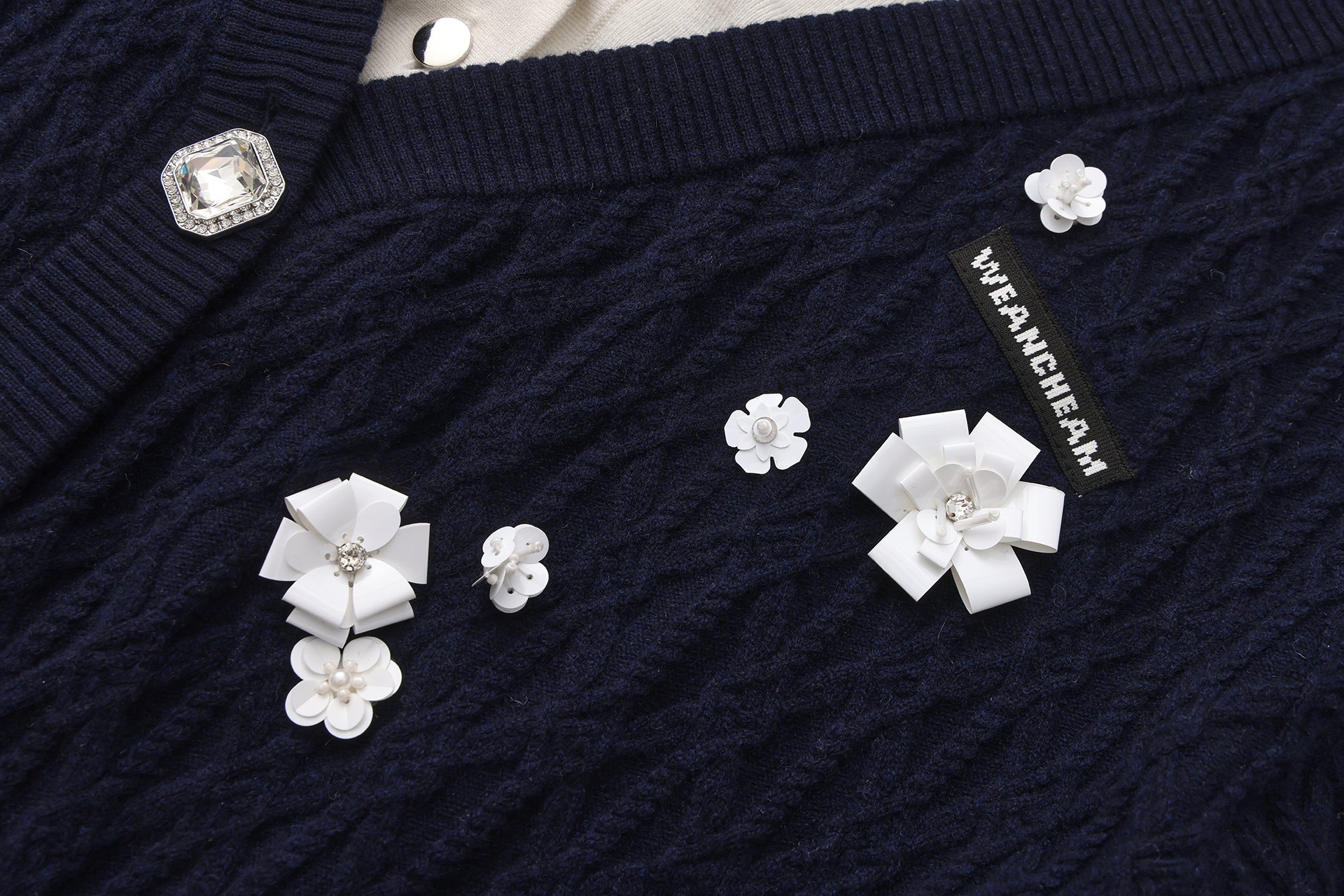 Close-up of bead embellishments and lace-trim collar on faux two-piece cardigan