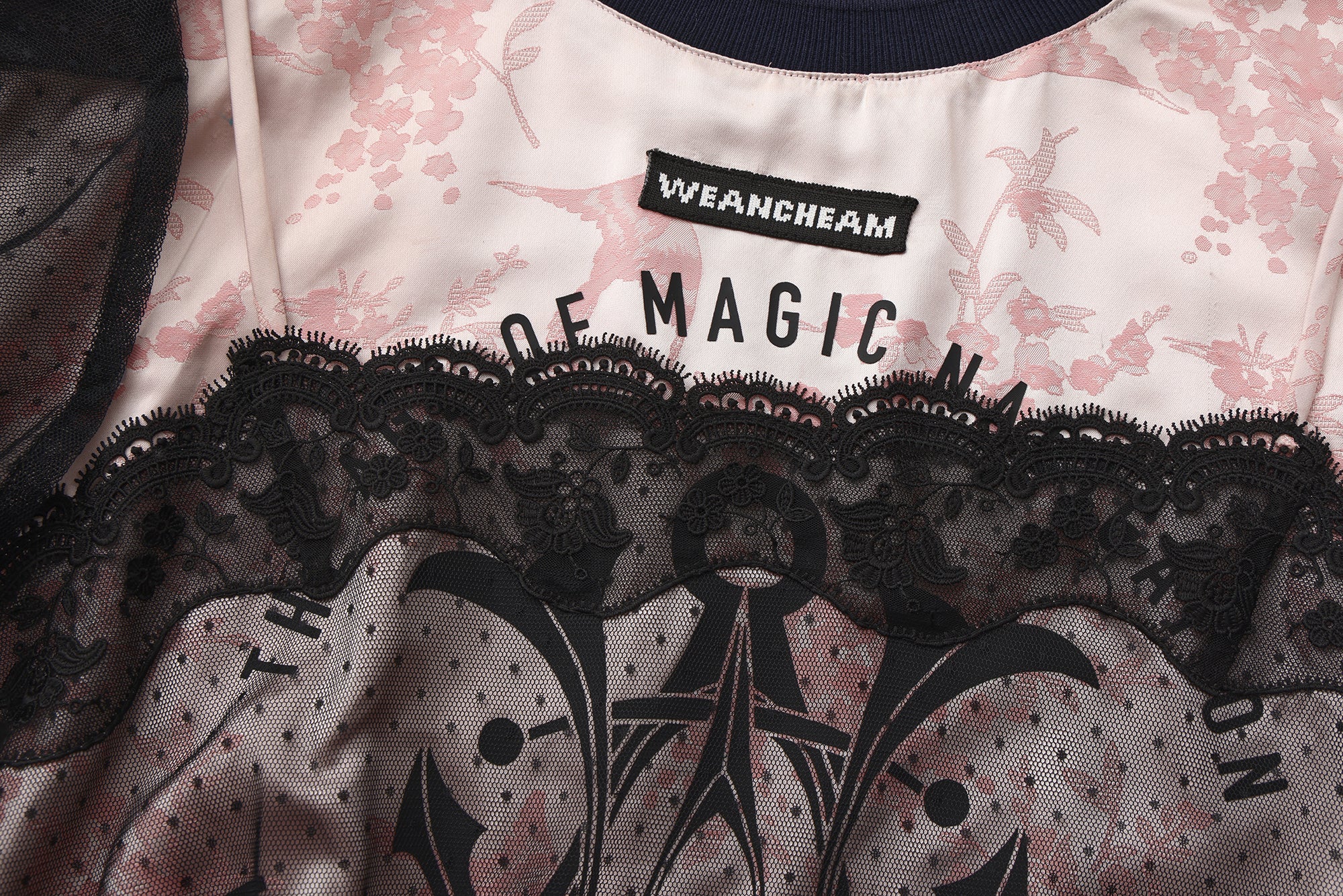 Close-up of detachable mesh sleeve and lace trim detail on satin sports dress