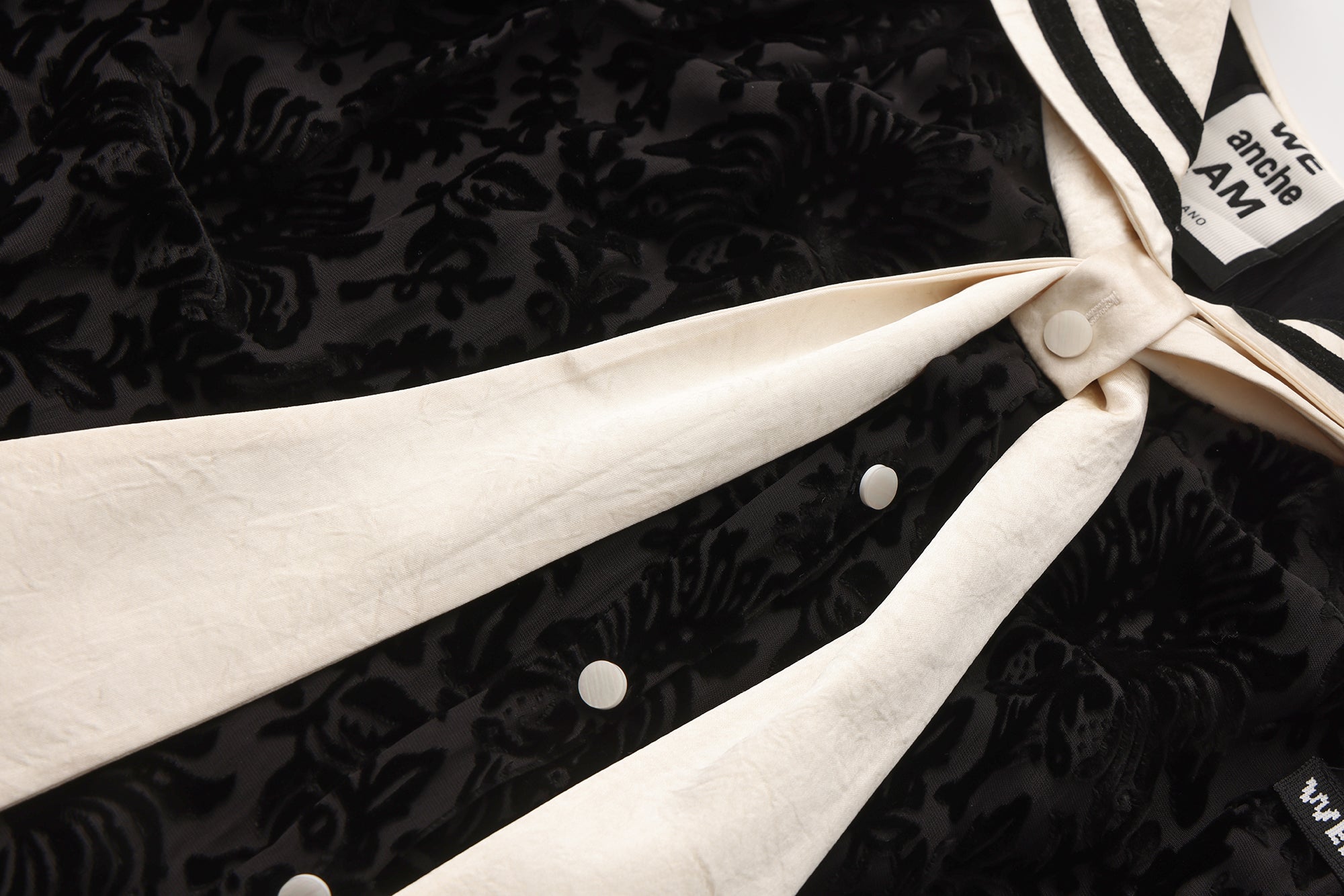 Close-up of ribbon neckline and smooth breathable fabric on navy collar dress