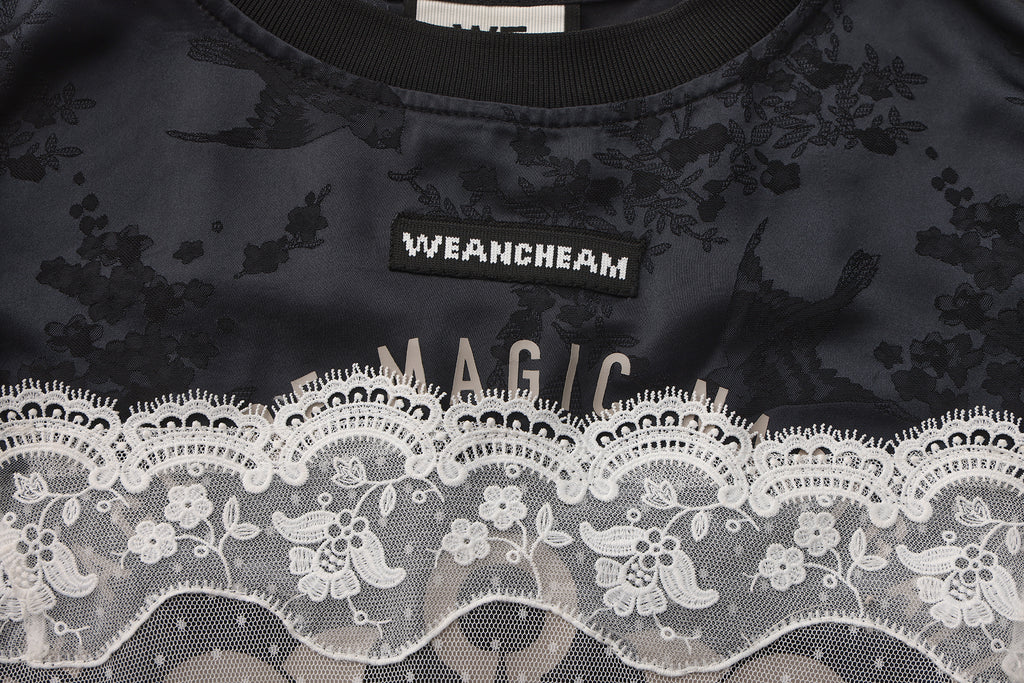Close-up of detachable mesh sleeve and lace trim detail on satin sports dress